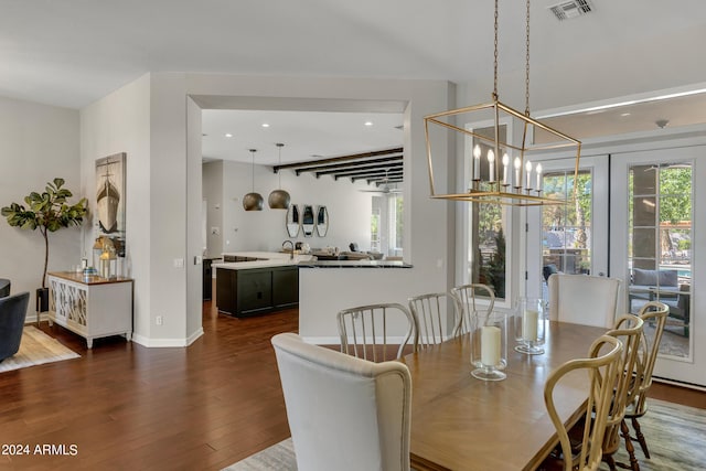 dining space with french doors, dark hardwood / wood-style floors, and an inviting chandelier