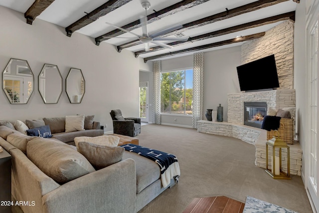 carpeted living room with ceiling fan, a fireplace, and beamed ceiling