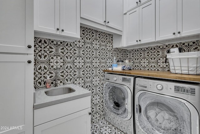 laundry area featuring washing machine and dryer, sink, and cabinets