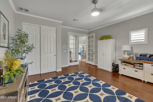 interior space featuring dark hardwood / wood-style floors, a closet, crown molding, and french doors