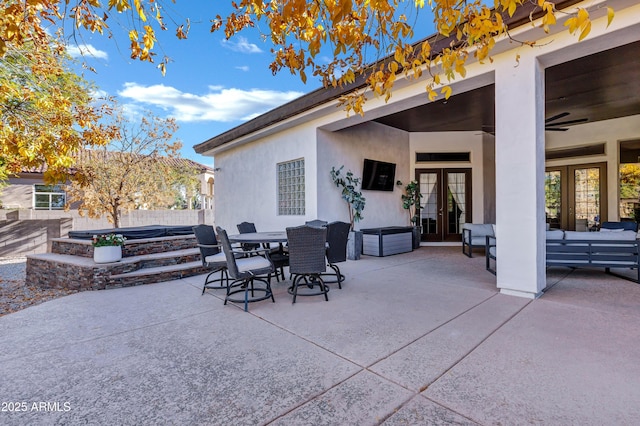 view of patio / terrace featuring a jacuzzi, french doors, ceiling fan, and outdoor lounge area