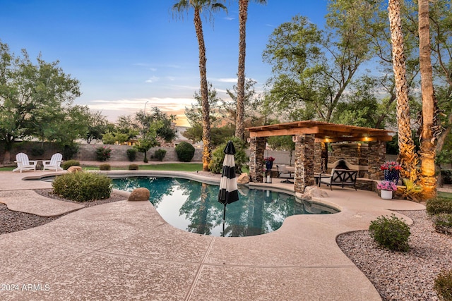 pool at dusk featuring a patio area