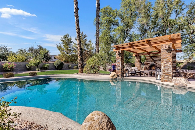 view of pool featuring an outdoor stone fireplace and a patio