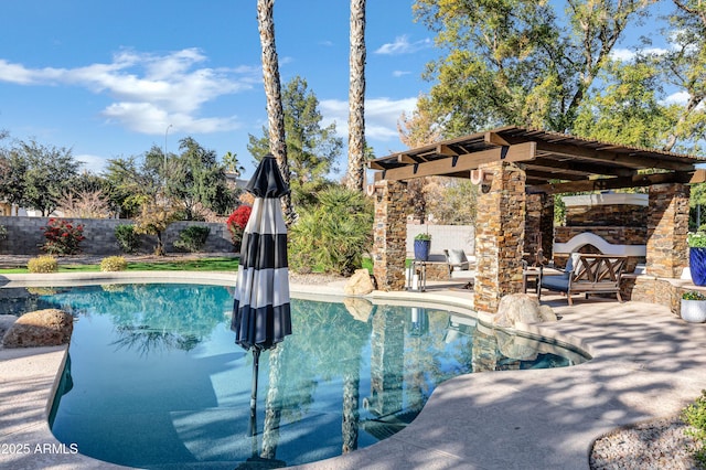 view of pool with an outdoor stone fireplace and a patio area