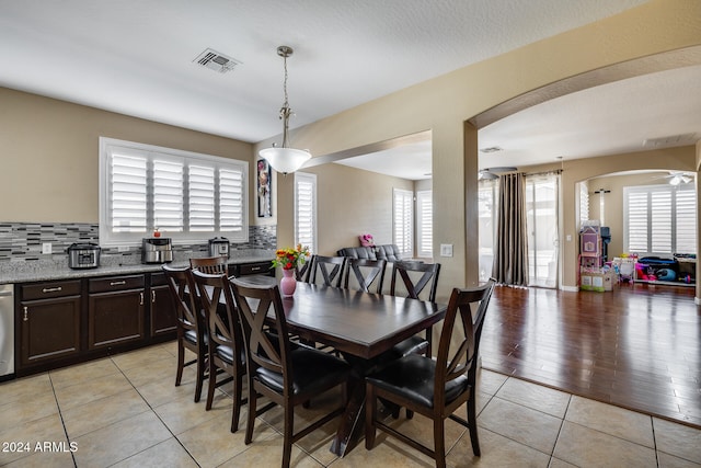 dining room with ceiling fan, a textured ceiling, and light wood-type flooring