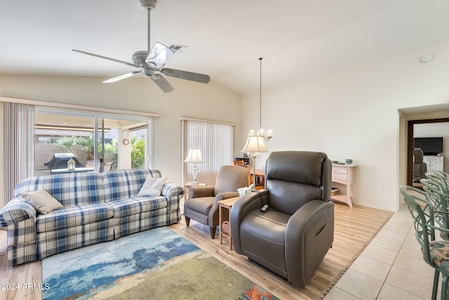 living room featuring ceiling fan with notable chandelier, light wood-type flooring, and lofted ceiling