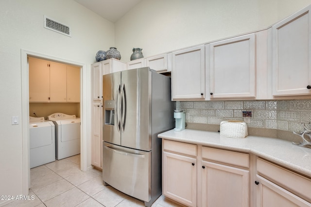 kitchen featuring washer and dryer, decorative backsplash, stainless steel refrigerator with ice dispenser, and light tile patterned floors