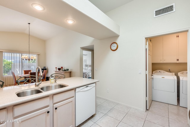 kitchen featuring dishwasher, sink, vaulted ceiling, decorative light fixtures, and washing machine and clothes dryer