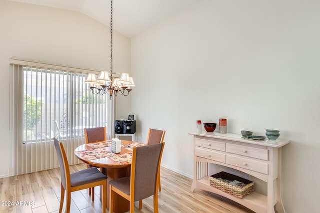 dining area with a chandelier, vaulted ceiling, and light hardwood / wood-style flooring