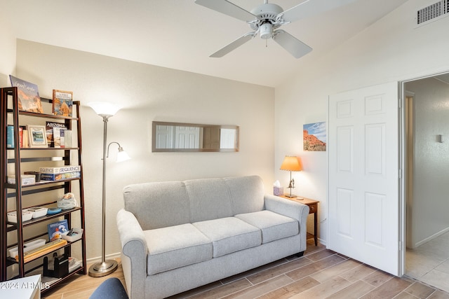 living room featuring vaulted ceiling, light hardwood / wood-style flooring, and ceiling fan