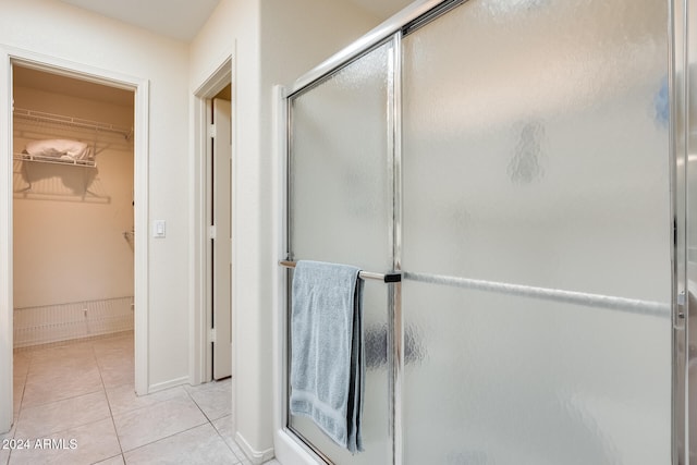 bathroom with tile patterned flooring and a shower with shower door