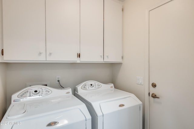 laundry room with washer and clothes dryer and cabinets