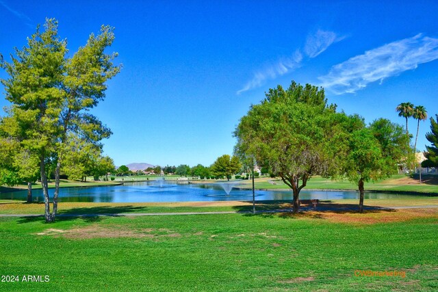 surrounding community featuring a water view and a lawn