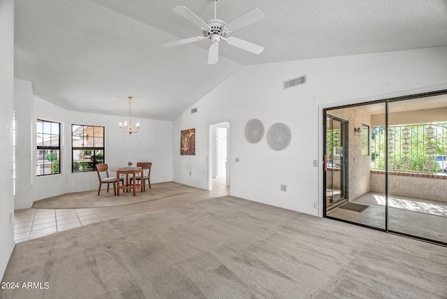 unfurnished living room with light carpet, high vaulted ceiling, a healthy amount of sunlight, and ceiling fan with notable chandelier