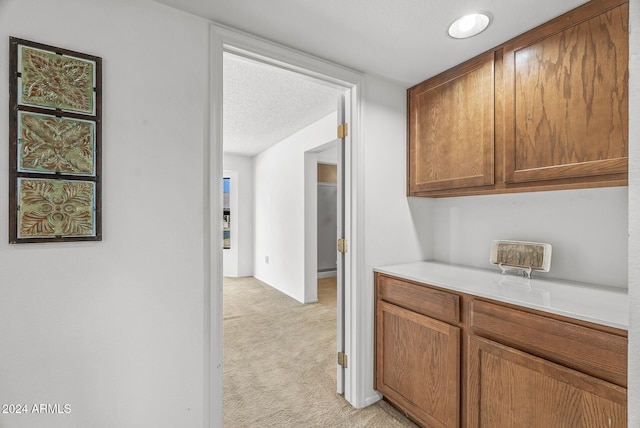 kitchen featuring light carpet and a textured ceiling