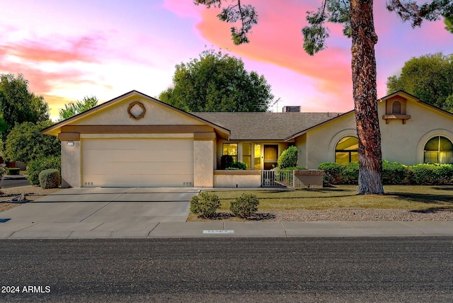 ranch-style home featuring a lawn and a garage