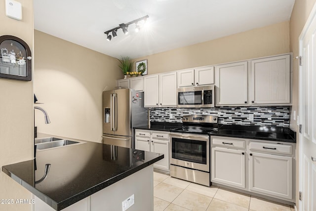 kitchen featuring sink, stainless steel appliances, track lighting, white cabinets, and light tile patterned flooring