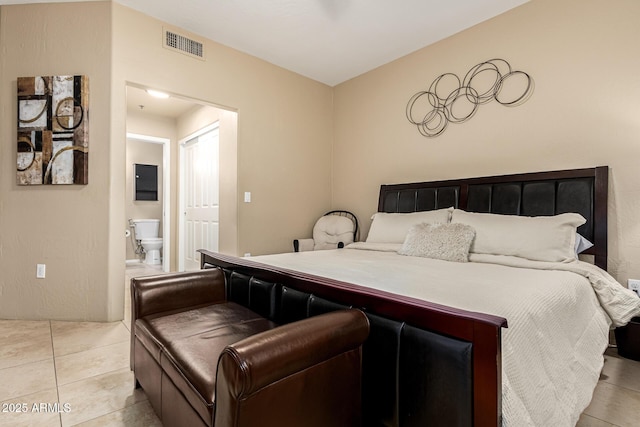 bedroom featuring light tile patterned floors and ensuite bathroom