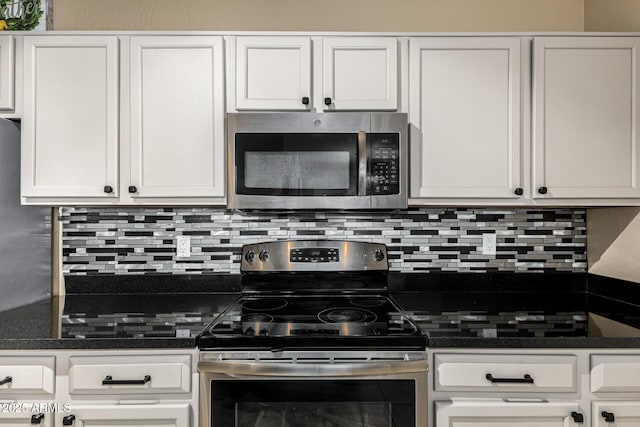 kitchen with tasteful backsplash, stainless steel appliances, dark stone counters, and white cabinets