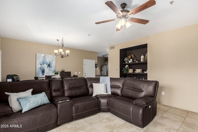 living room with built in shelves, ceiling fan with notable chandelier, and light tile patterned floors