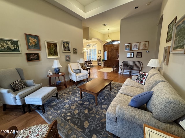 living room featuring a towering ceiling and hardwood / wood-style floors