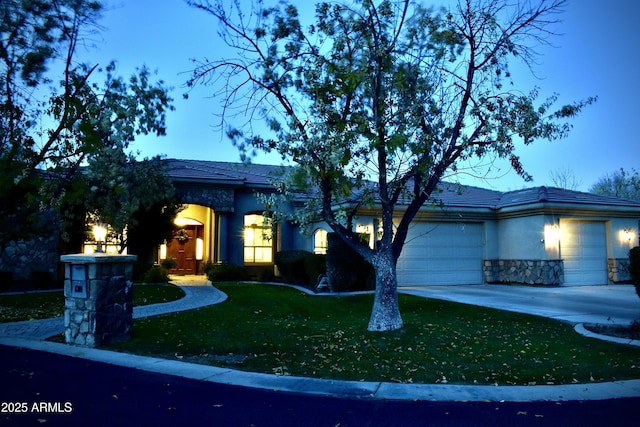 view of front of home featuring a garage and a yard