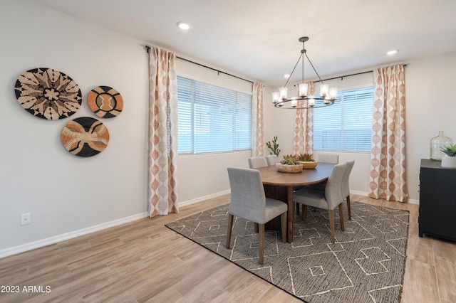 dining area featuring a notable chandelier, plenty of natural light, and wood finished floors