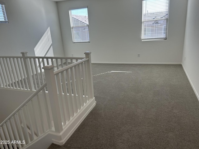 carpeted empty room featuring baseboards