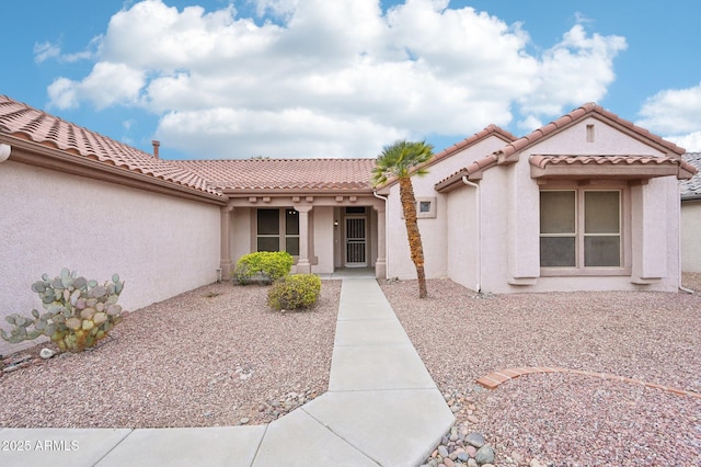 property entrance with stucco siding and a tile roof