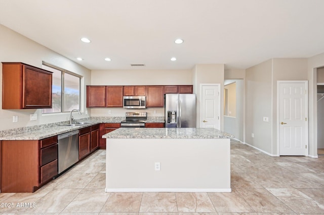 kitchen with visible vents, a kitchen island, recessed lighting, appliances with stainless steel finishes, and a sink