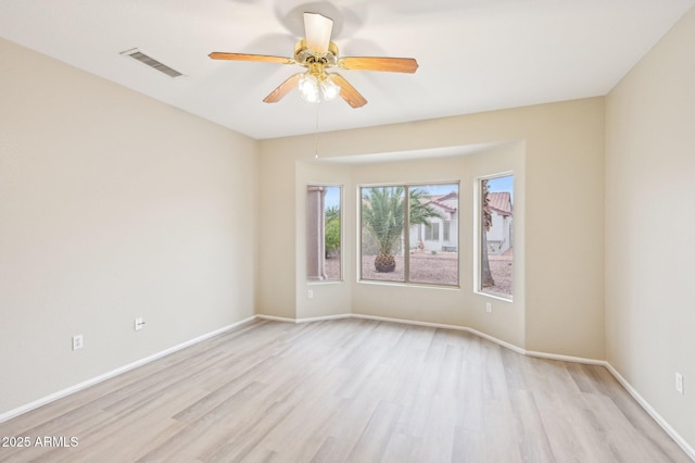 unfurnished room with baseboards, visible vents, a ceiling fan, and light wood-style floors