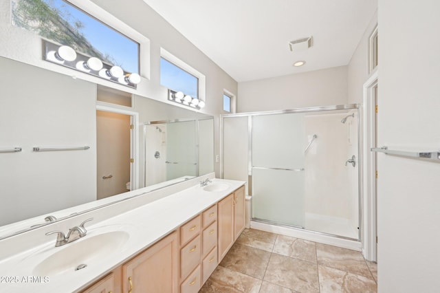 full bath featuring a sink, visible vents, a stall shower, and double vanity