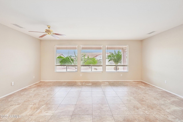 unfurnished room with visible vents, a healthy amount of sunlight, and a ceiling fan