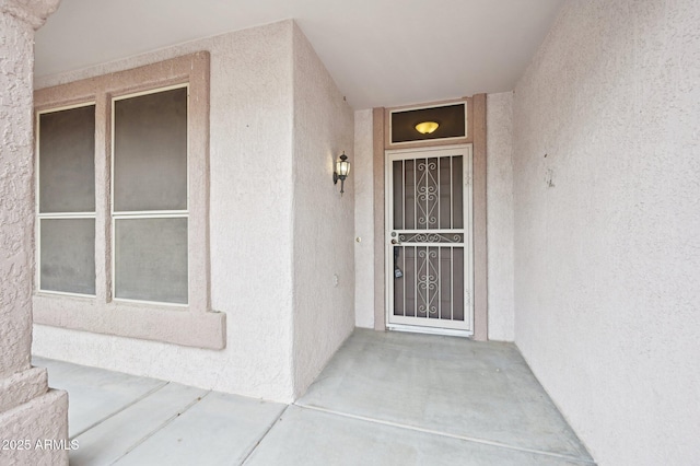 entrance to property featuring stucco siding