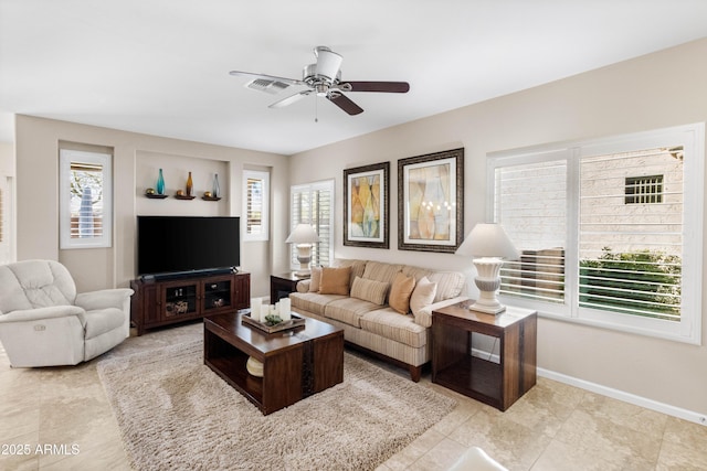 living room with visible vents, ceiling fan, and baseboards