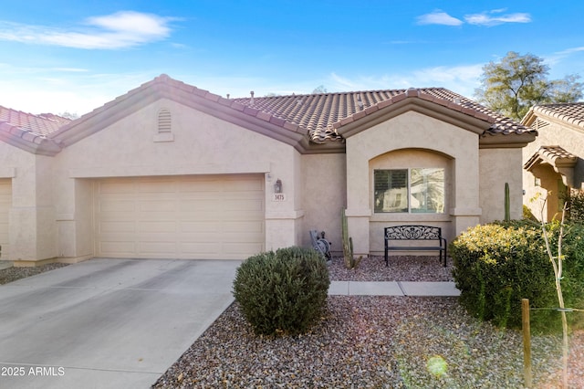 view of front facade with a garage, a tiled roof, driveway, and stucco siding