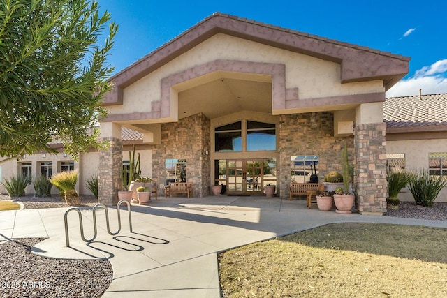 doorway to property featuring stone siding and stucco siding