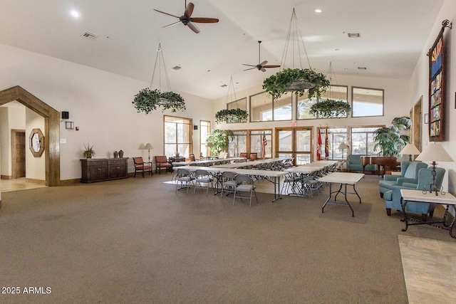 interior space featuring open floor plan, high vaulted ceiling, visible vents, and a ceiling fan