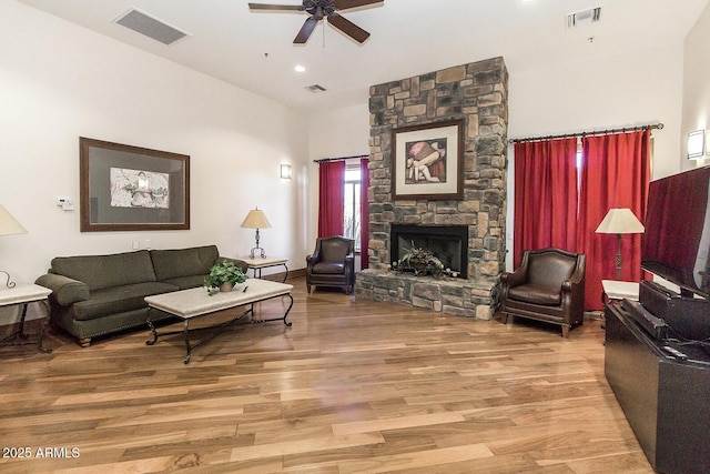 living area featuring a fireplace, visible vents, and wood finished floors