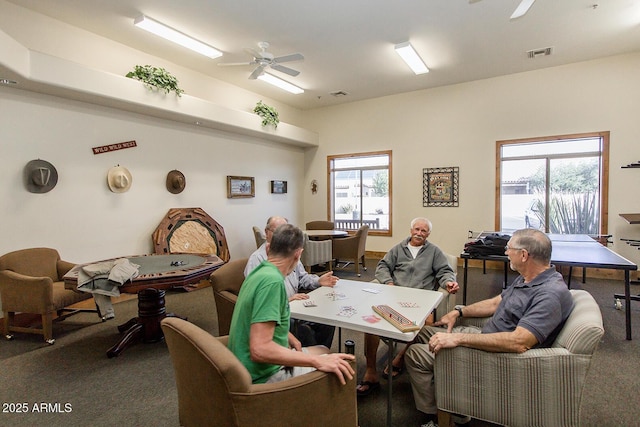 recreation room with carpet, visible vents, and ceiling fan