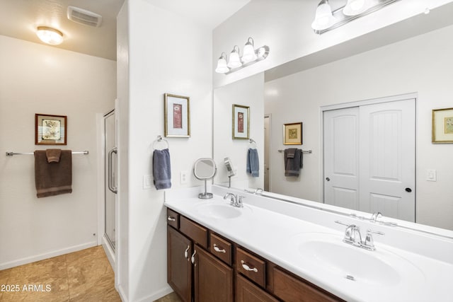 full bath featuring a stall shower, visible vents, a sink, and double vanity