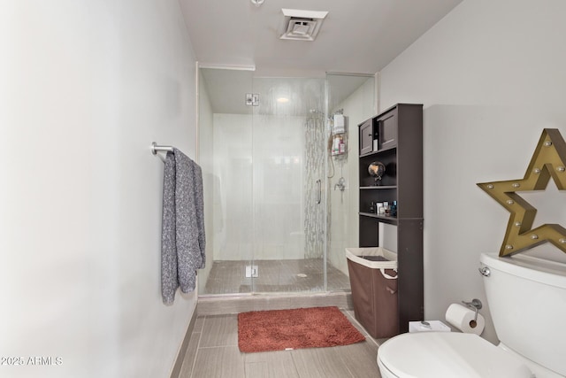 bathroom with toilet and an enclosed shower