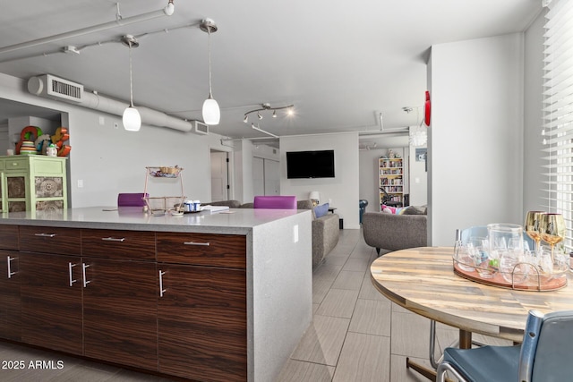 kitchen featuring decorative light fixtures and dark brown cabinets