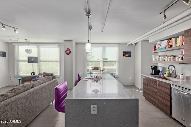 kitchen with stainless steel dishwasher, a healthy amount of sunlight, sink, and pendant lighting