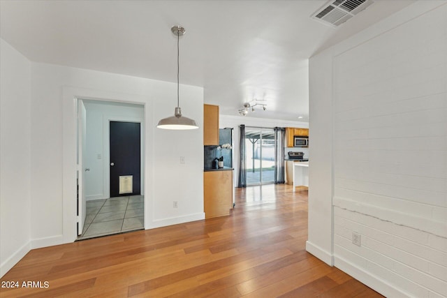 unfurnished dining area featuring light wood-type flooring