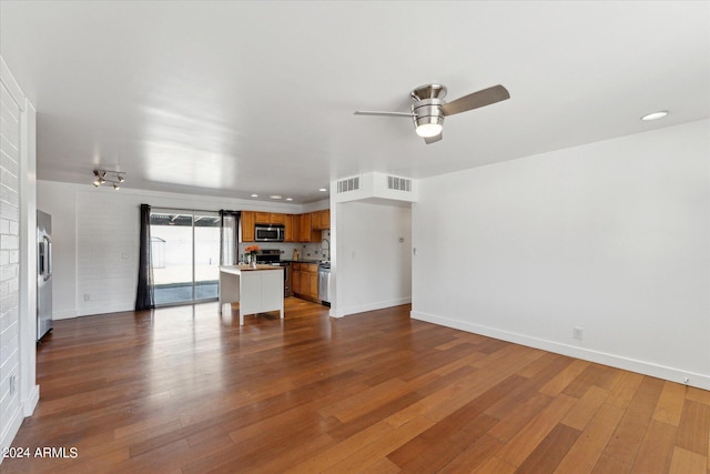 unfurnished living room with ceiling fan and dark wood-type flooring