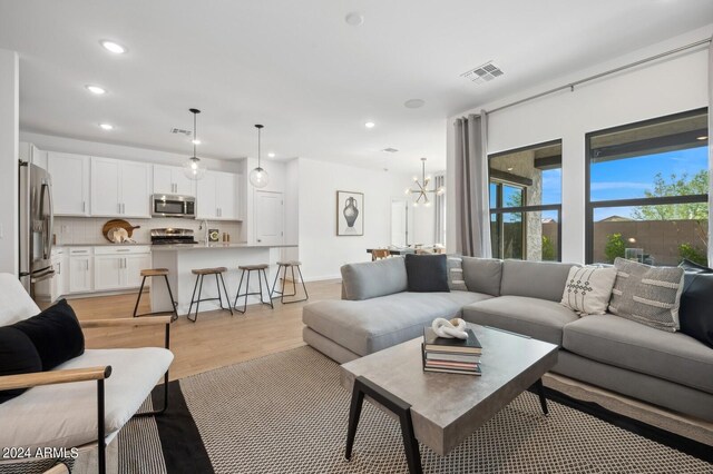 living room featuring a chandelier and light hardwood / wood-style floors