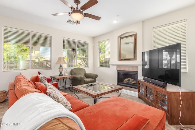 living room featuring ceiling fan and a fireplace