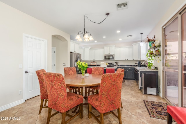 tiled dining area with a healthy amount of sunlight, a notable chandelier, and sink