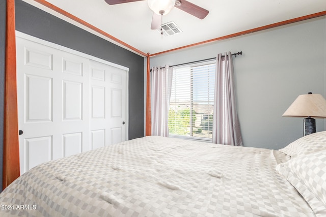 bedroom with a closet, ceiling fan, and crown molding